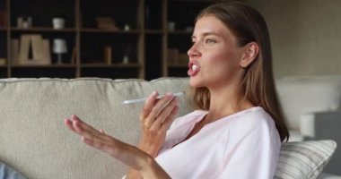 Genç bayan, kanepeye otur ve hoparlörden konuşma yap.