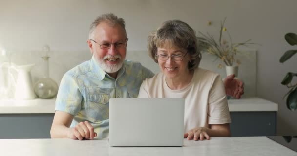 Nyugdíjas szülők beszélnek felnőtt gyerek videojáték segítségével laptop — Stock videók