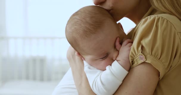 Schattig kind slapen op zorgzame moeder armen in de lichte kamer — Stockvideo