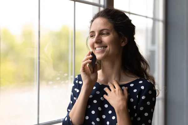 Sonriente joven hispana alegre sosteniendo llamada de teléfono celular. — Foto de Stock