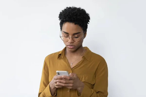 Mujer afroamericana milenaria concentrada usando teléfono celular. — Foto de Stock