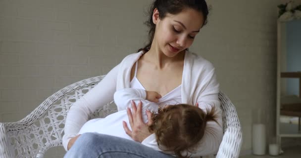 Serene millennial latin mother feed little toddler girl with breast — Vídeo de Stock