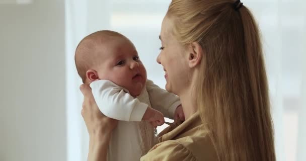 Opgewonden jong mam kus zuigeling op schattig gezicht klein neus — Stockvideo