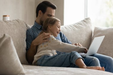 Neşeli küçük çocuk ve ilgili baba dizüstü bilgisayar kullanıyor..