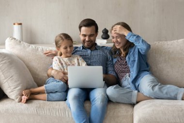 Evdeki bilgisayarı kullanarak mutlu tasasız aile.