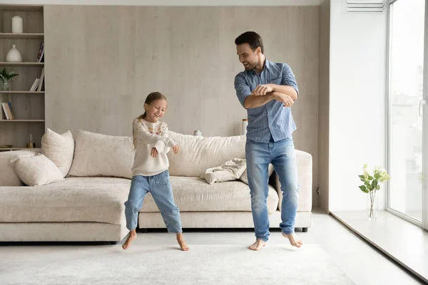 Glücklicher junger Vater und kleine Tochter tanzen zu Hause. — Stockfoto