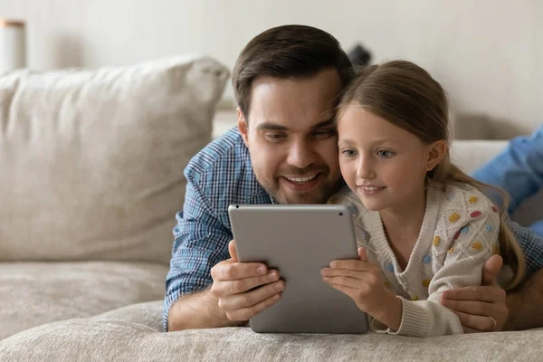 Счастливый молодой отец и маленькая дочь с помощью цифрового планшета. — стоковое фото