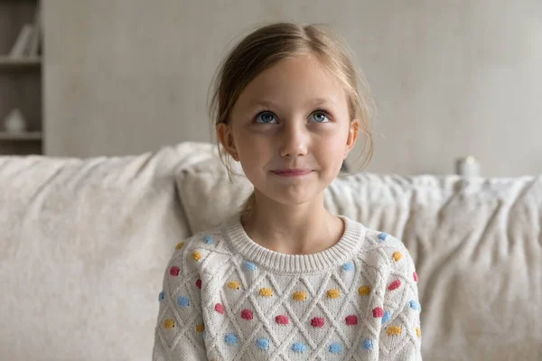 Joyful schattig klein kind meisje kijken omhoog, verloren in gedachten. — Stockfoto