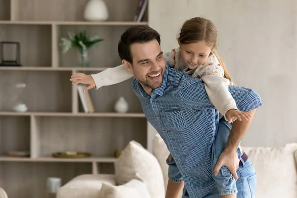 Père heureux tenant sur le dos fille mignonne. — Photo