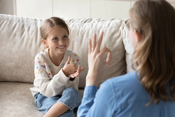 Glad liten unge som använder teckenspråk, kommunicerar med mamma. — Stockfoto