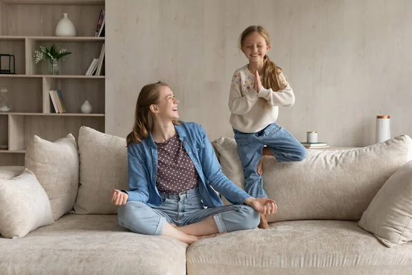 Vreugdevolle twee generaties familie doen yoga oefeningen thuis. — Stockfoto