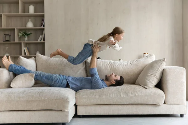 Relaxed millennial daddy having fun with joyful child daughter. — Stock Fotó