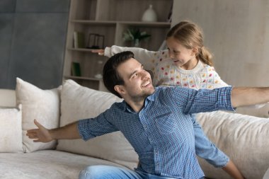 Neşeli genç baba küçük kızıyla eğleniyor..