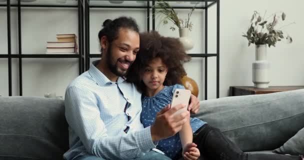 Африканская семья использует мобильный телефон весело смотреть онлайн забавный контент — стоковое видео