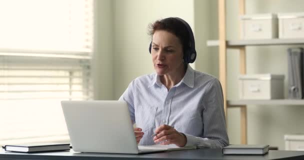 Oudere vrouw leraar leiden online klasse door app op laptop — Stockvideo