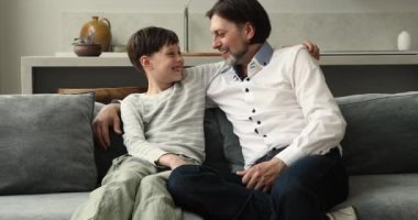 Baba ve oğul koltuğa oturarak bahse giriyorlar.