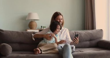 Mutlu anne, rahat ol. Küçük oğlu internette akıllı telefondan sörf yapıyor.
