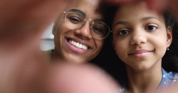 Mom and daughter faces, view through joined fingers showing love — стокове відео