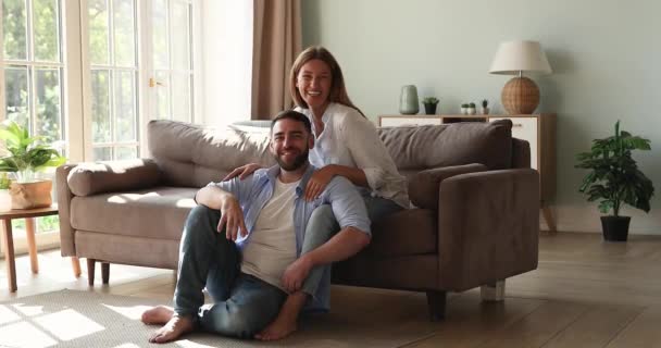 Family portrait young couple posing at new apartment living room — Stockvideo