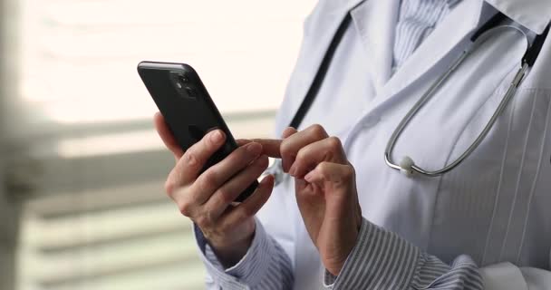 Close up female therapist standing in clinic office holds cellphone — Vídeo de Stock