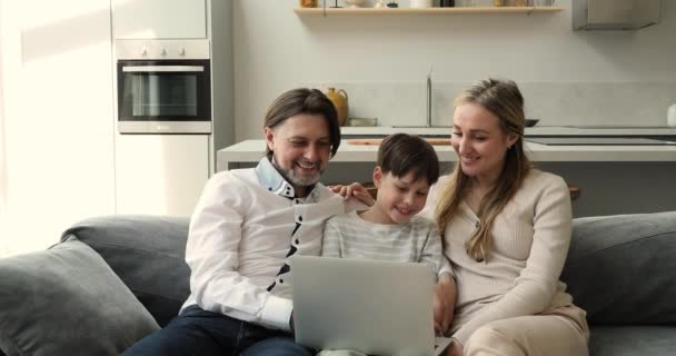 Couple and 8s son watch family comedy movie on laptop — Stockvideo