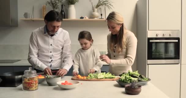 Niña ayuda a los padres con la preparación de la cena vegetariana — Vídeos de Stock
