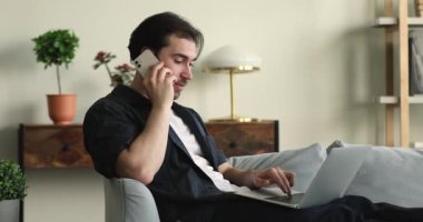 Cep telefonundaki erkek serbest konuşma laptopla çalışıyor.