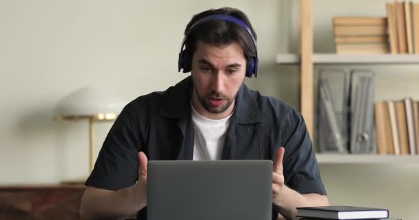 Homem usar fones de ouvido levar briefing usar aplicativo de videocall e laptop — Vídeo de Stock
