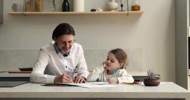 Père enseigner petite fille mignonne à dessiner des photos dans carnet de croquis — Video