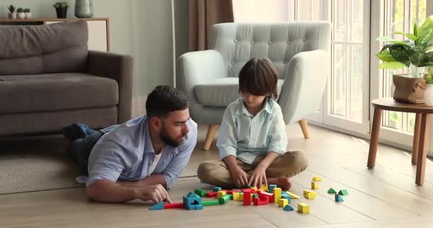 Young dad little son engaged in game with constructor set — Stockvideo
