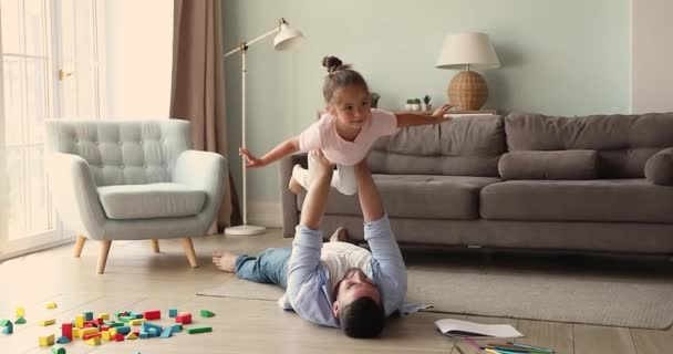 Little girl enjoy imaginary flight in air on dad hands — стоковое видео