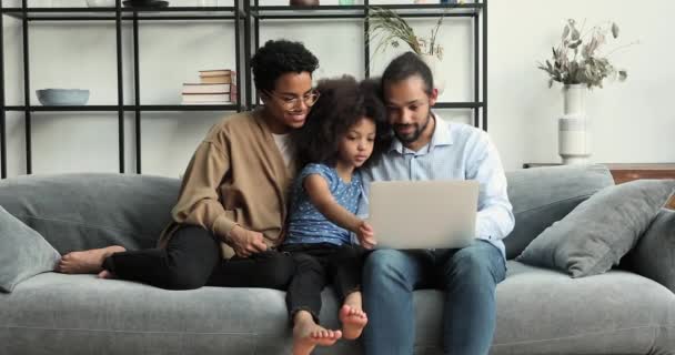 Young African couple and little daughter use laptop discuss purchase — 图库视频影像