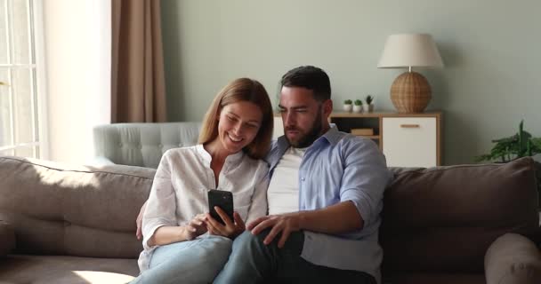 Friendly millennial spouses smiling on internet memes on smartphone screen — 图库视频影像