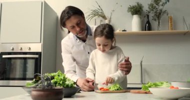 Baba ve küçük kız mutfakta sebze salatası hazırlayın.