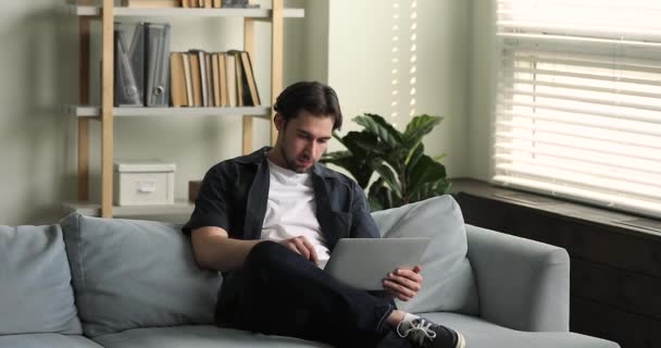 Young man sit on sofa texting messages using laptop — Vídeo de Stock