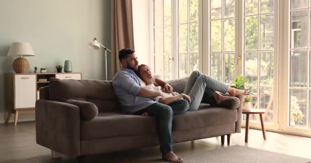 Millennial couple relax on couch indoors talk enjoy independent life — Vídeo de Stock