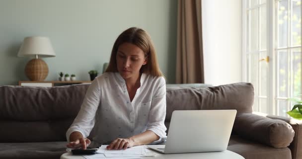 Zenuwachtige verwarde jonge vrouw berekenen betalingen voor rekeningen met problemen — Stockvideo