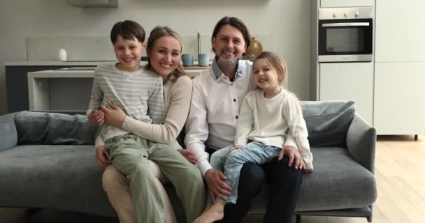 Couple and children have fun sit on sofa at home — Video Stock