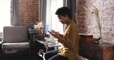 Güzel Afrikalı genç bir kadın. Gülümse ve cep telefonu kullan.