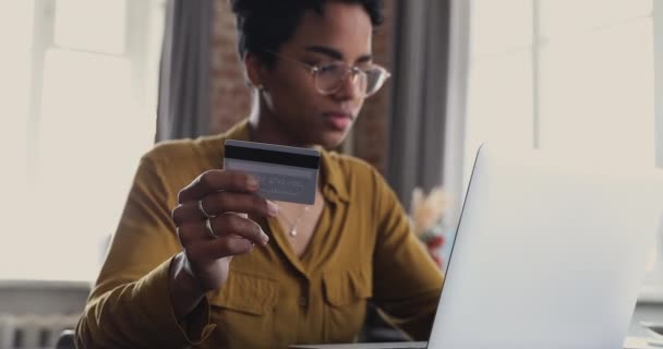 Afrikaanse vrouw houdt credit card gebruik laptop doen online winkelen — Stockvideo