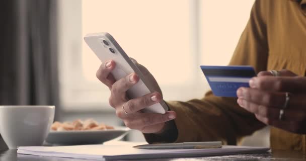 Vrouw maken veilige geldovermakingen gebruik van mobiele telefoon en kaart, close-up — Stockvideo