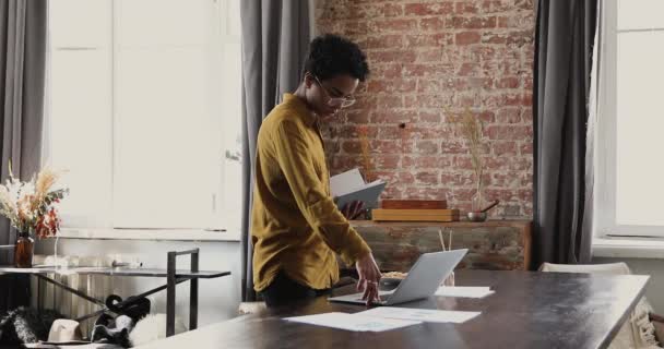 Dizüstü bilgisayarda yazan Afrikalı kadın, kişisel ajandasında notlar yazıyor. — Stok video