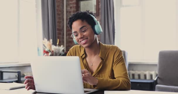 African woman wear headphones talk to friend by video call — 图库视频影像