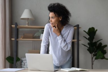 Bilgisayarda çalışan düşünceli Afro-Amerikan kadın..