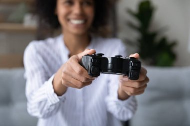 Kadın ellerindeki uzaktan kumandaya odaklan.