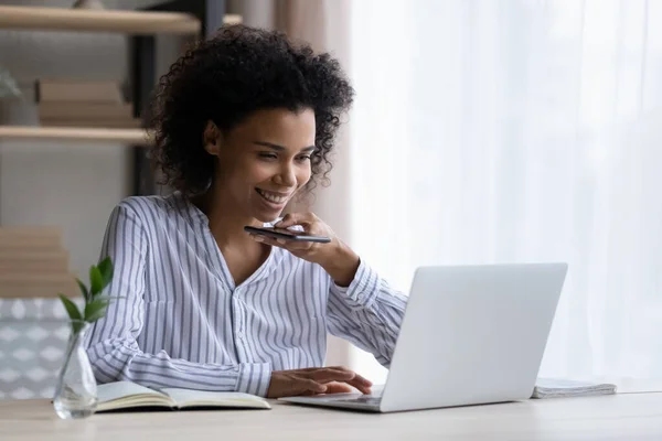 Feliz joven mujer de negocios afroamericana grabando mensaje de audio en la oficina. —  Fotos de Stock