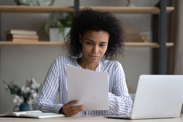 Thoughtful millennial african american businesswoman analyzing paper report. — Stock Photo, Image