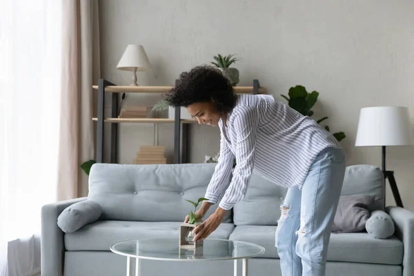 Happy young african american housewife improving interior. — Stock Photo, Image