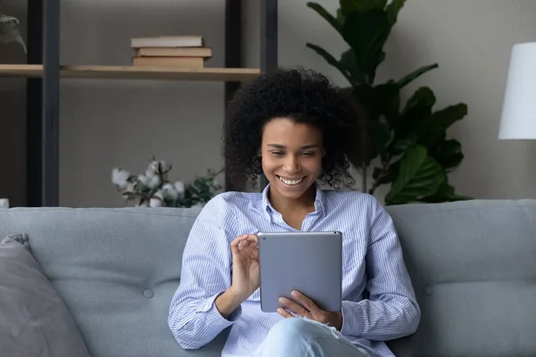 Feliz hermosa joven afroamericano usando tableta en casa. — Foto de Stock