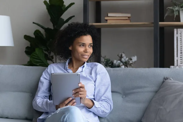 Soñadora joven africana sosteniendo tableta digital. — Foto de Stock